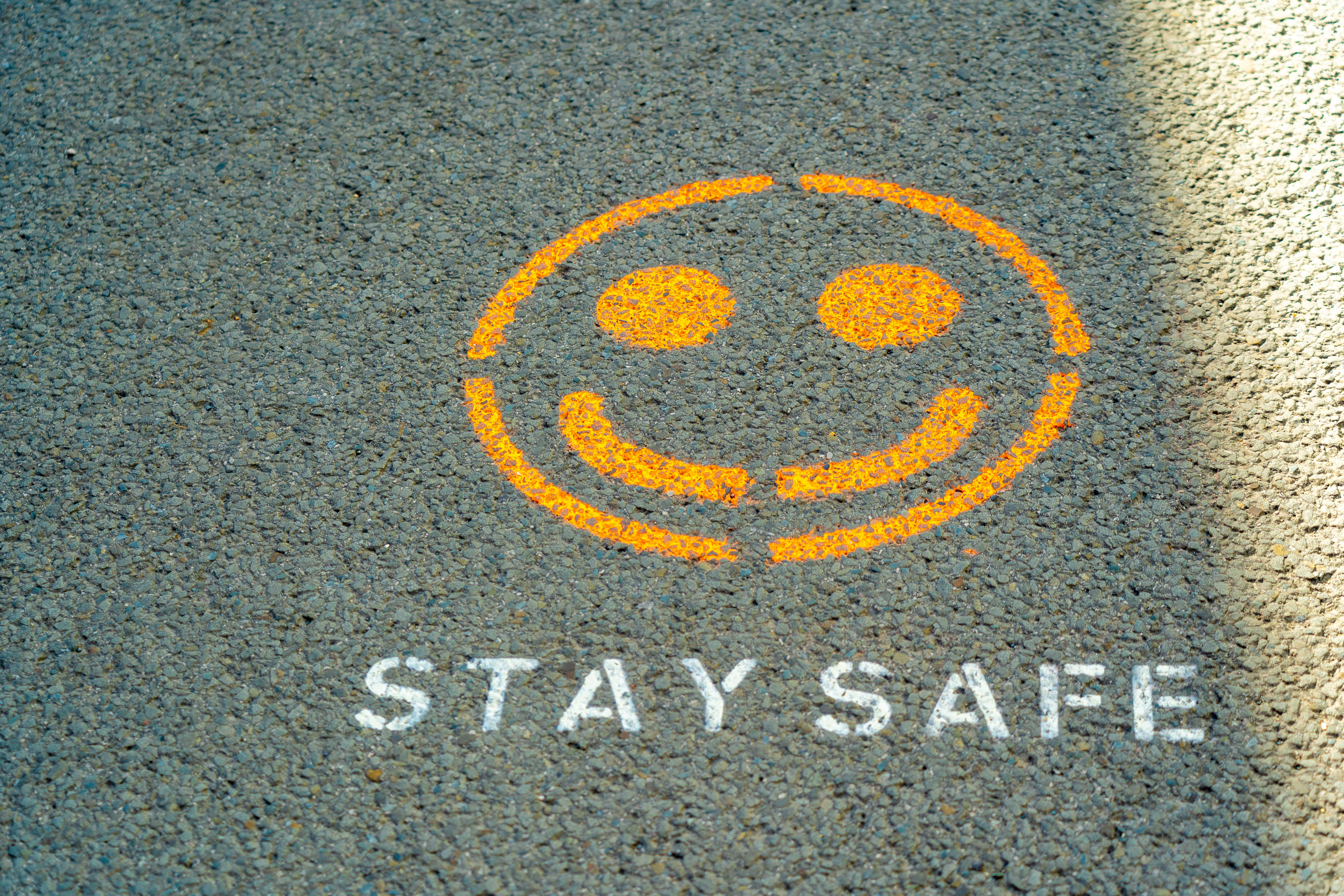 Sidewalk graffiti says "stay safe"