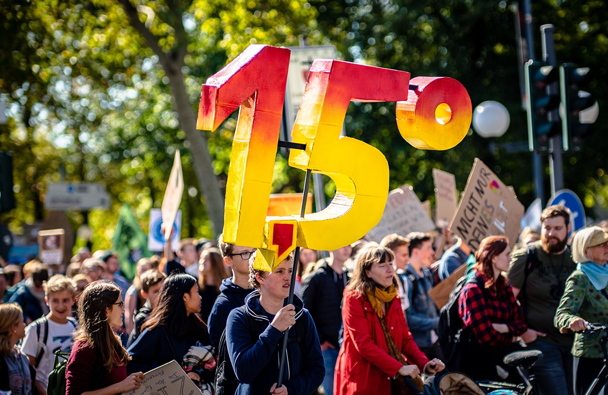 An climate activist holds a 1.5 degrees Celsius sign