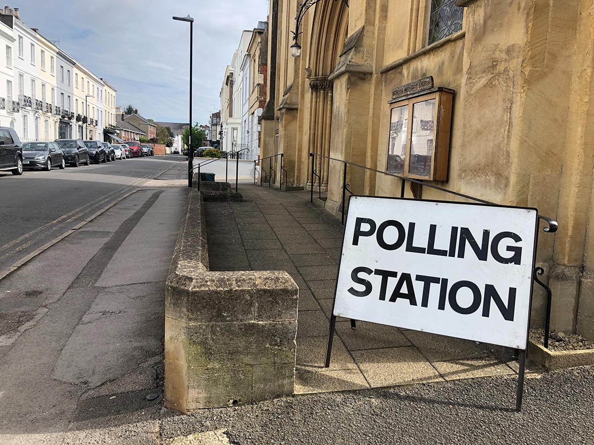 Photo of a polling station sign on a street corner