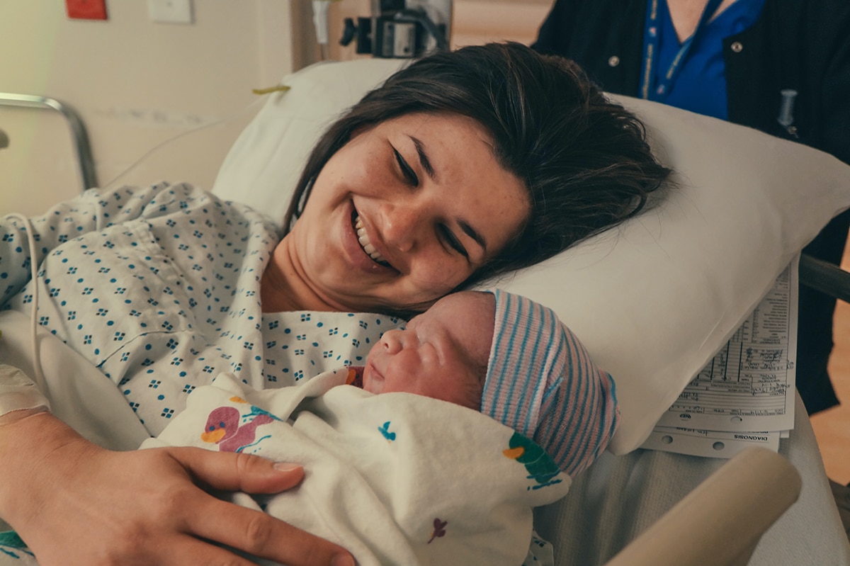 Photo of a smiling mother and her newborn baby