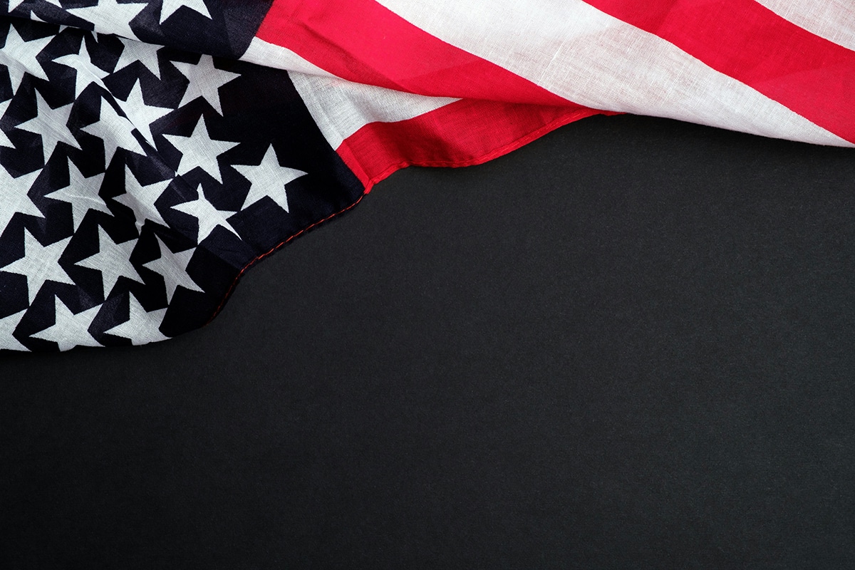 An America flag draped over a somber black background