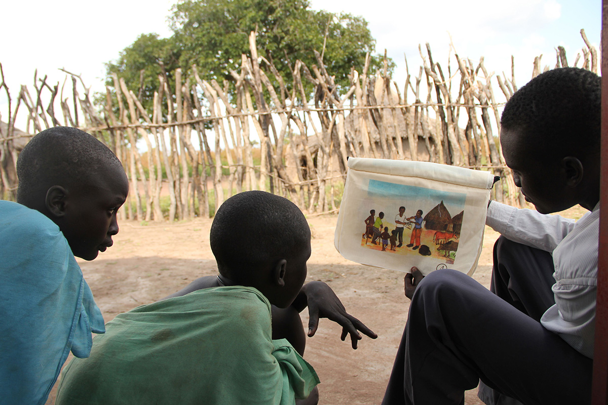 A field officer in South Sudan uses a flip chart to show children how to avoid contracting guinea worm disease