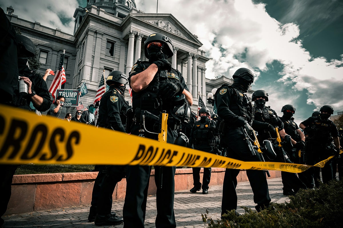 Police and protesters stand outside the Colorado State Capitol after the 2020 election