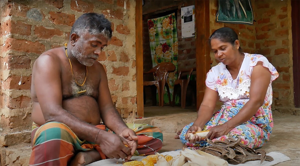 A Sri Lankan farmer sits outside with his wife