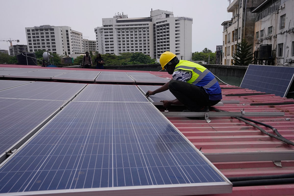 Oladapo Adekunle, an engineer with Rensource Energy, installs solar panels on a roof of a house in Lagos, Nigeria, Thursday, March 21, 2024. Funding for climate tech startups in Africa from the private sector is growing, but there's still a long way to go. (AP Photo/Sunday Alamba)