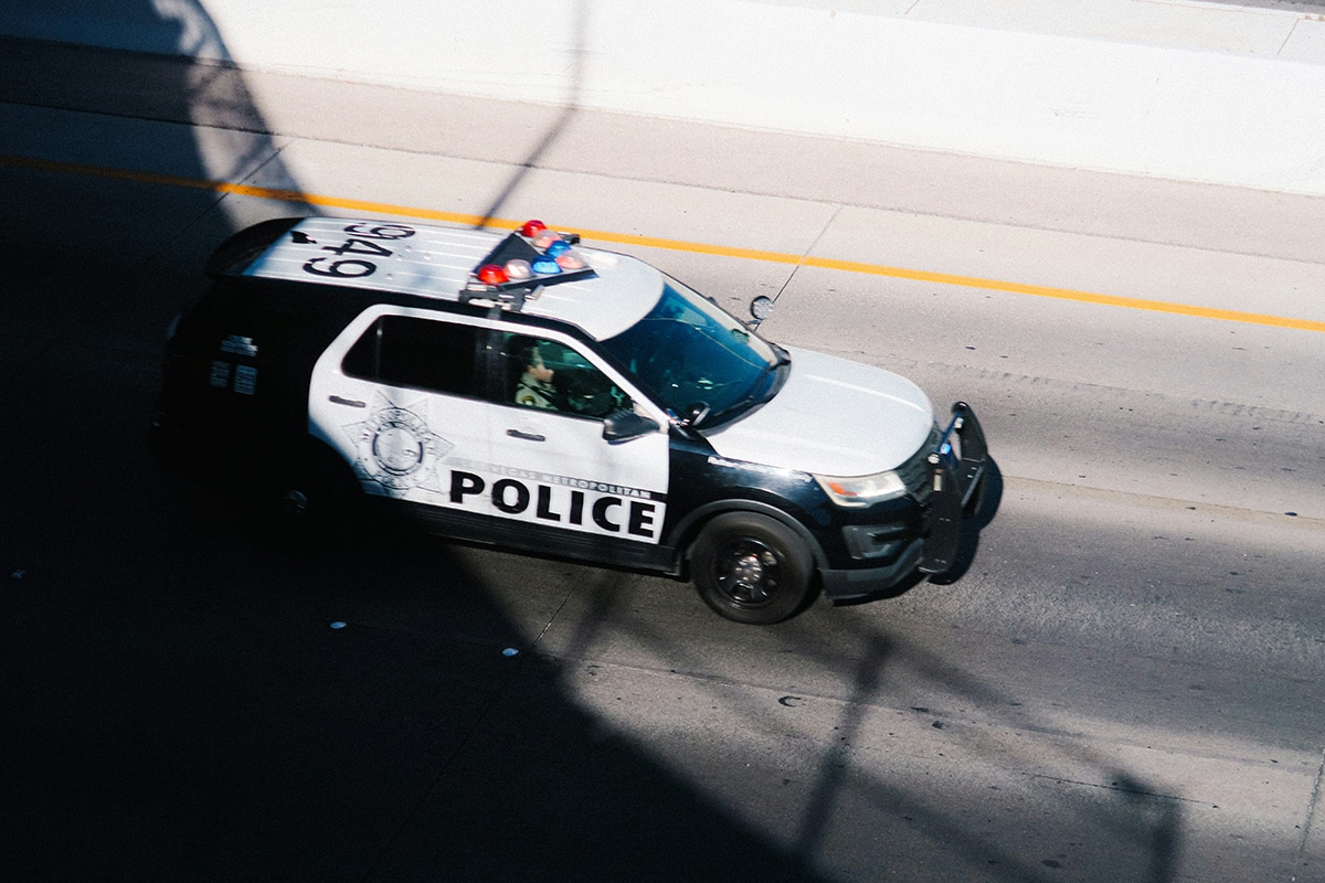 A police van drives on a street