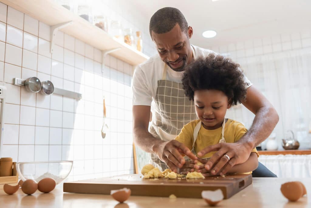 A father cooks in the kitchen with his child